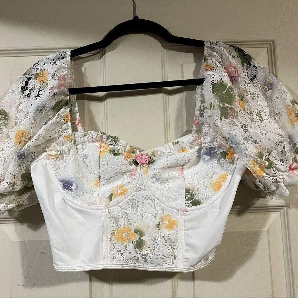 Sweet pastel flowers on a white, puffed sleeve crop top.